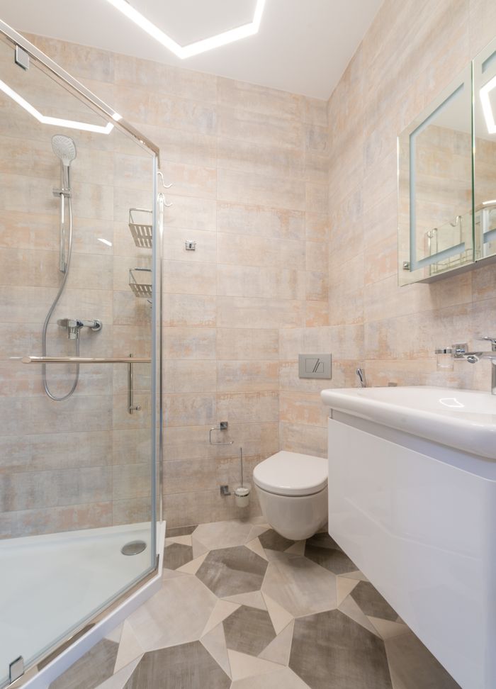 Bright, clean bathroom featuring ceramic tiles, a glass shower, and modern fixtures.