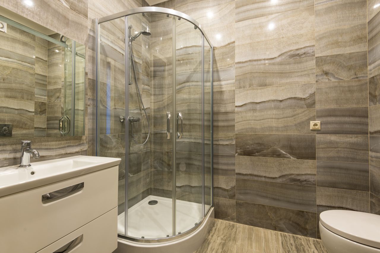 Luxurious modern bathroom featuring a glass shower and stylish sink setup.